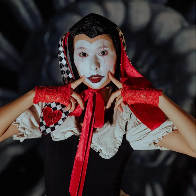 Customer in harlequin jester makeup wearing the jester bonnet